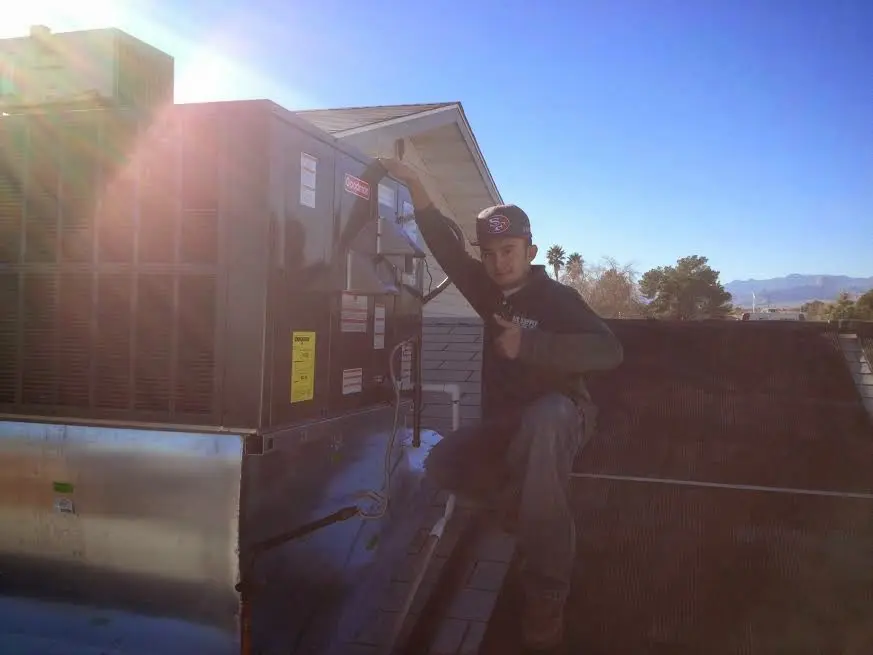 HVAC technician performing AC Tune-Up on a rooftop unit in Paducah